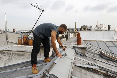 un couvreur français travaille le 24 août 2017 sur un toit en zinc d'un immeuble parisien